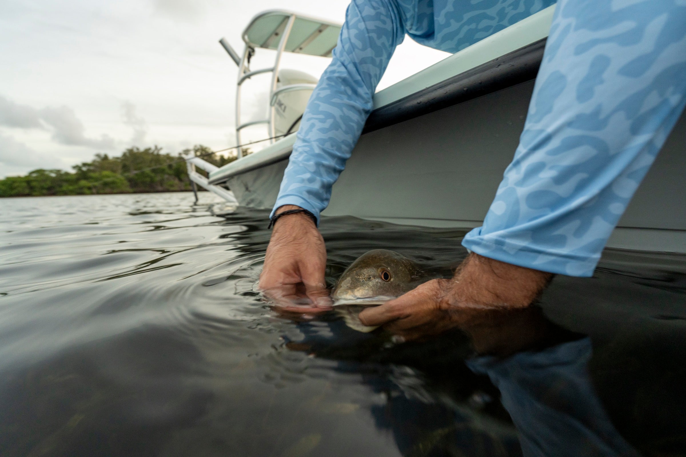 Angler releasing a redfish at the boat